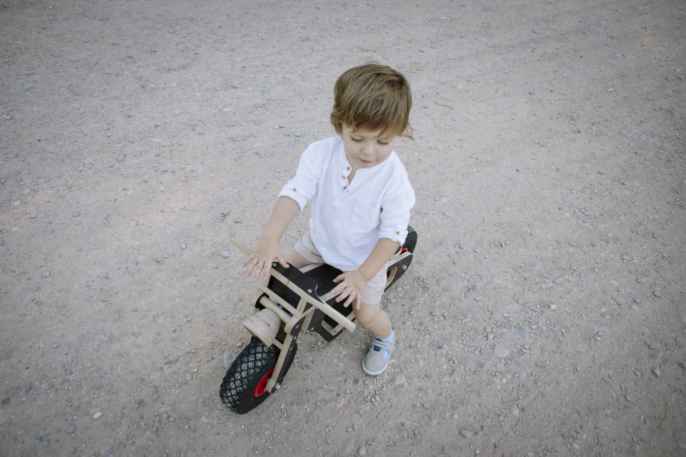 niño con bici de madera