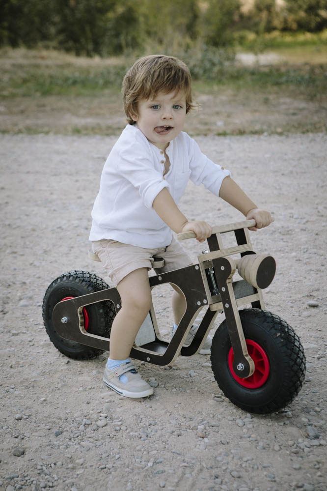 niño con bici de madera 3